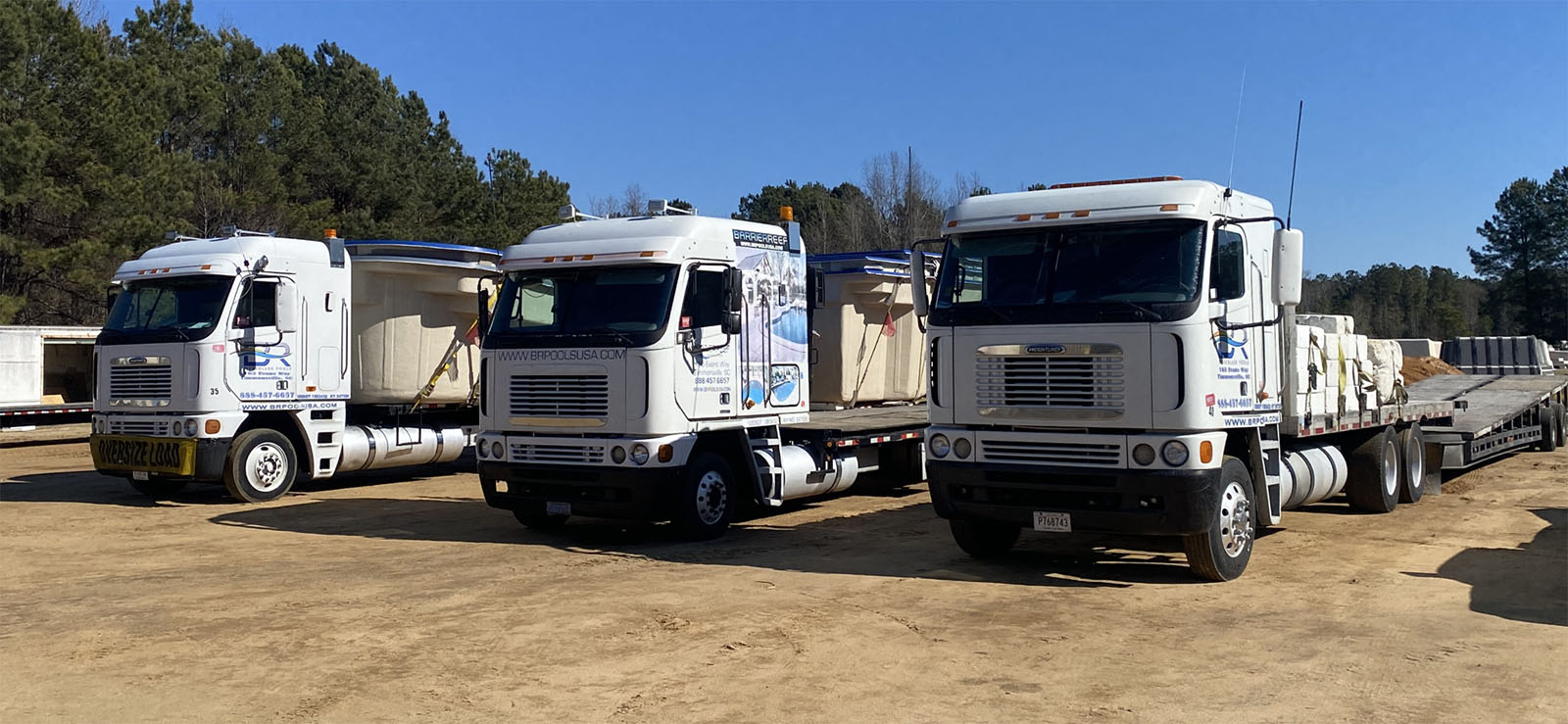Barrier Reef trucks lined up for in-ground fiberglass swimming pool delivery and transportation